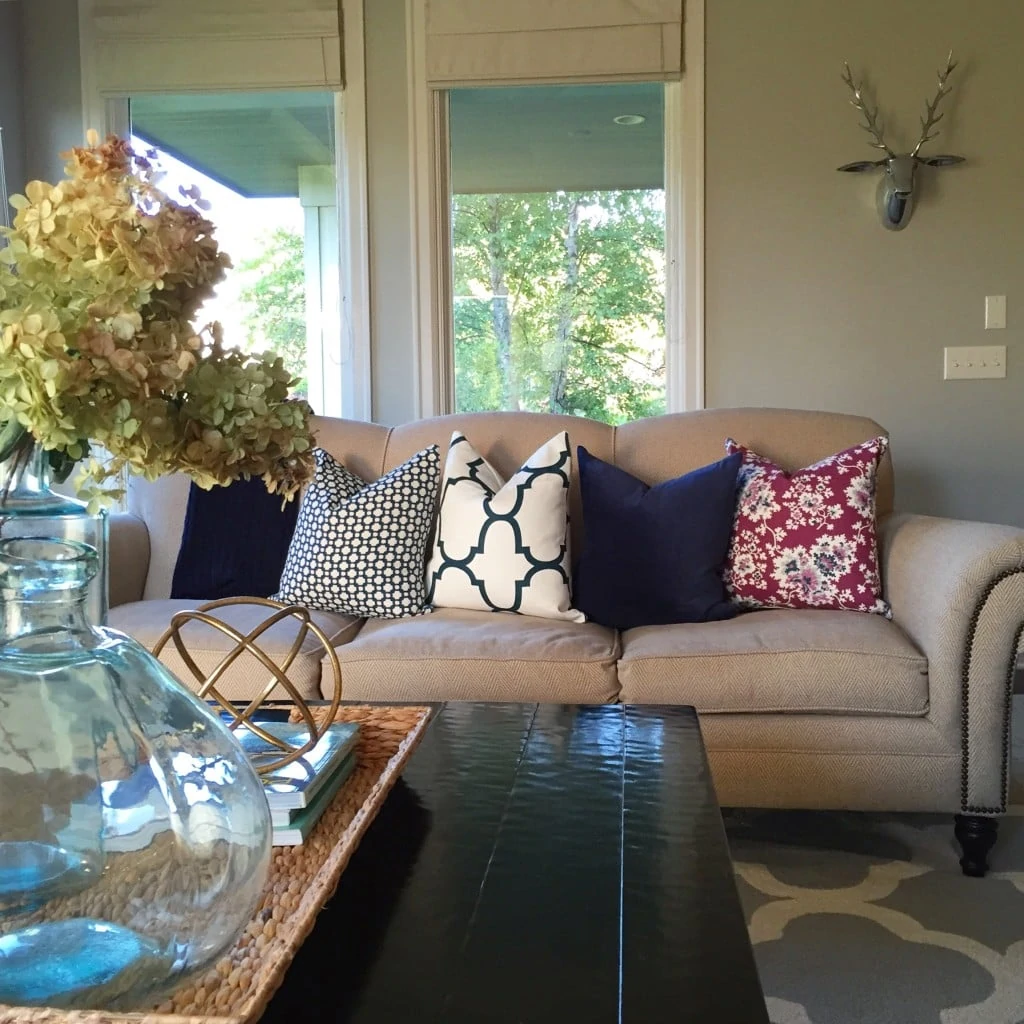 Fall living room with designer pillows in navy, white and plum.