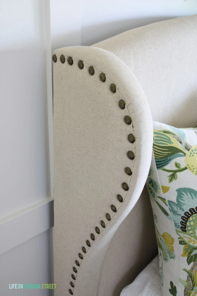 Detail shot of the wingback linen headboard with nailhead accents. 