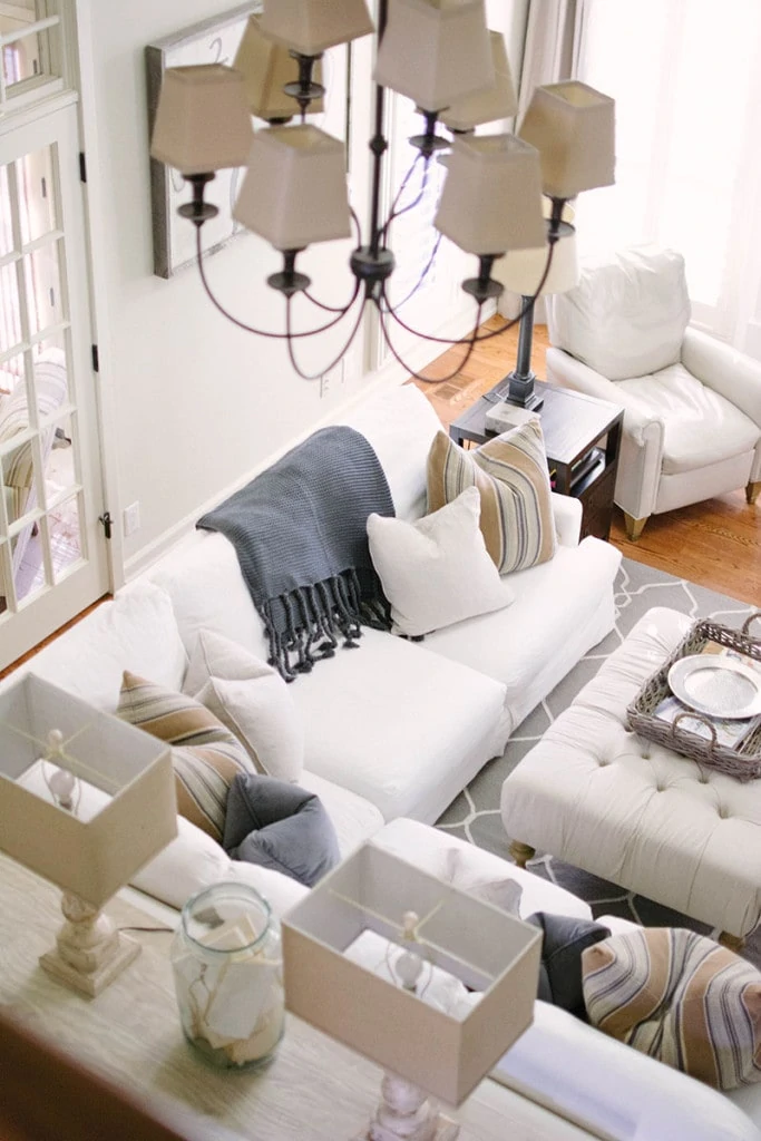 Living Room Overhead View with neutral home decor including a white linen sectional, striped pillows, reclaimed wood console table, a charcoal gray woven blanket and more!