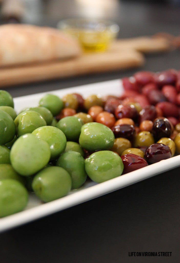 Up close picture of large green olives and smaller black olives.