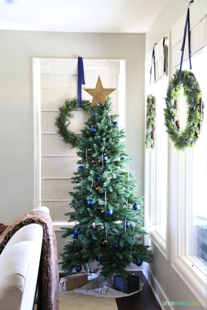 A Christmas tree with navy blue ornaments and glass icicles. I also love the wreaths hanging from the window with navy blue ribbon!
