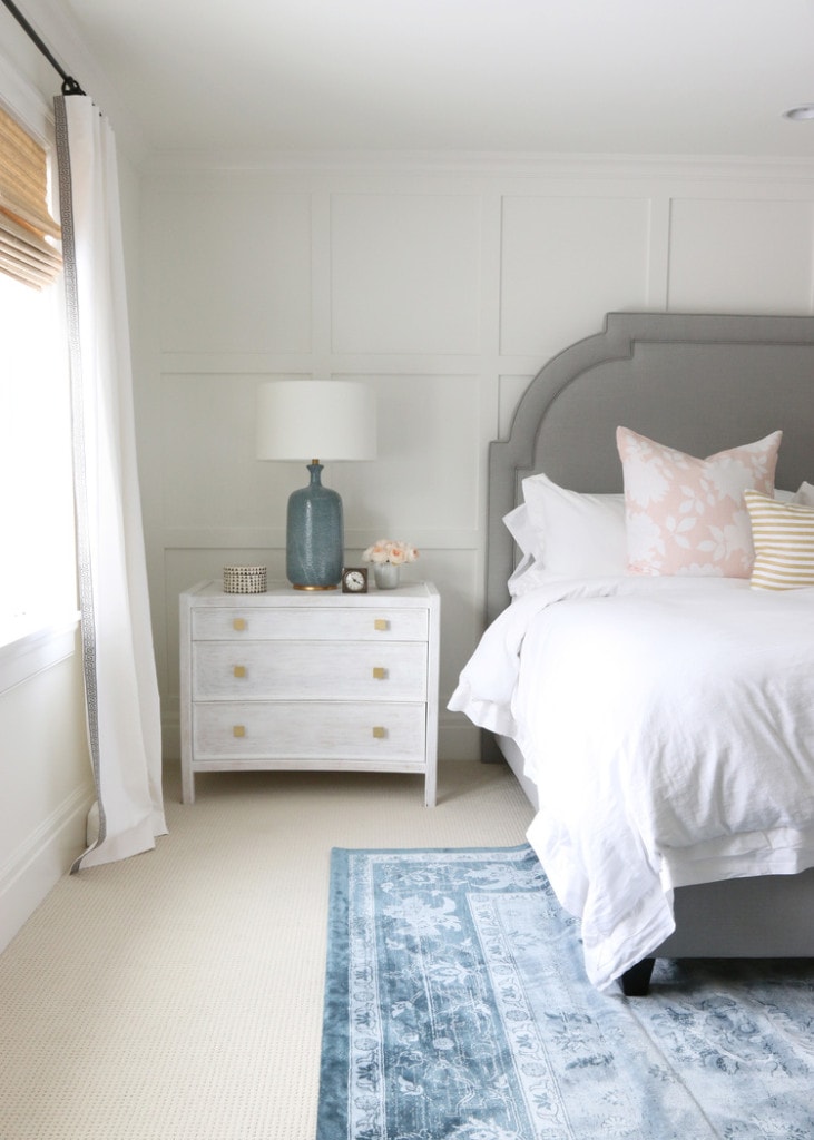 Bedroom with gray bed and blue rug.