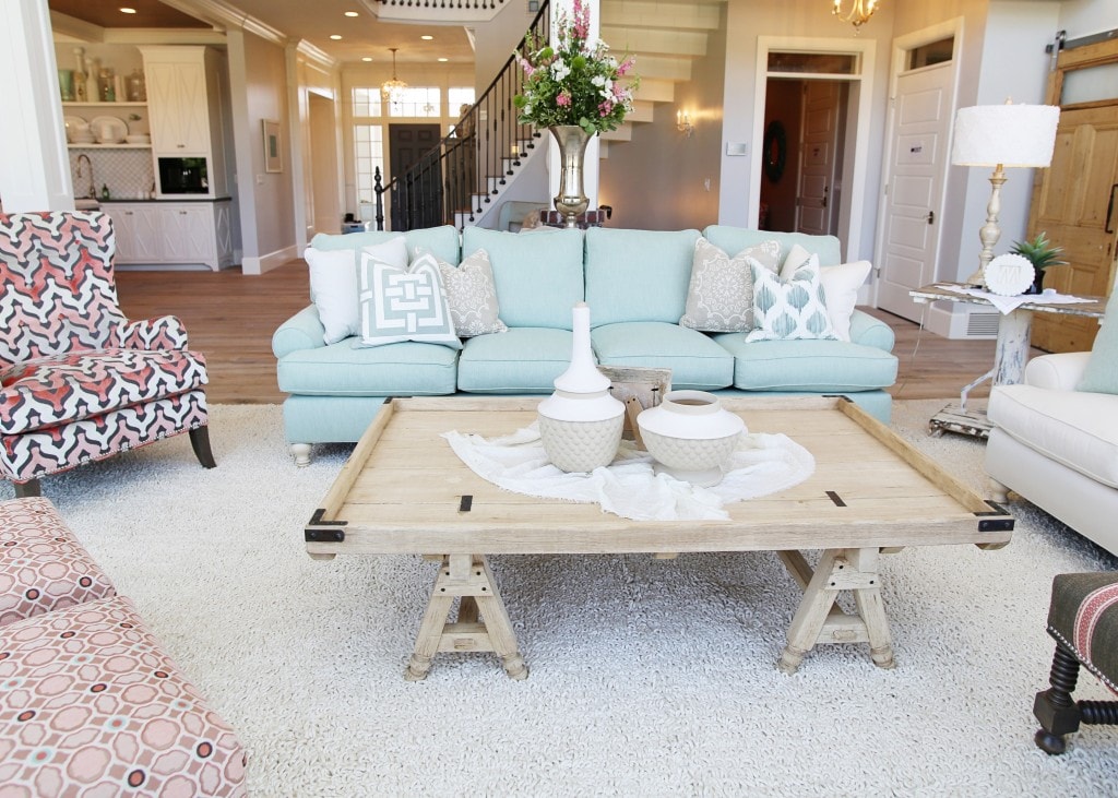 Living room with light blue couch and wooden table.