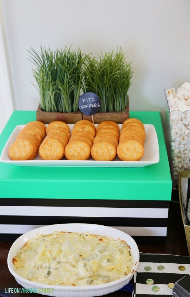 Ritz crackers on a plate in front of the hot artichoke dip.