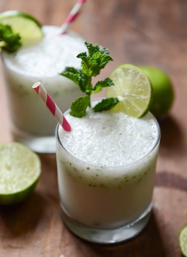 Frosty Coconut Mojitos and a red and white straw in the glass.