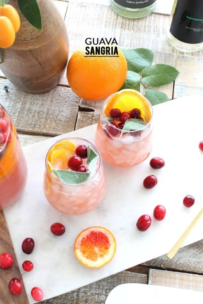 Guava Sangria in glasses with cranberries scattered beside it.