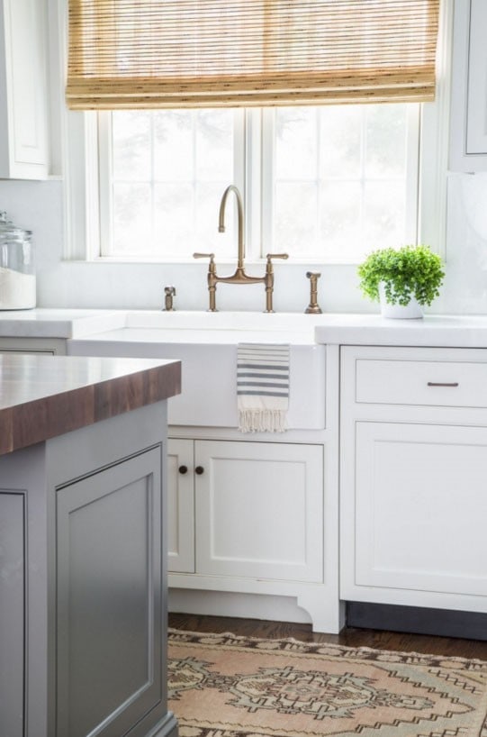 Kitchen with White Cabinets, Gray Island, Blush Pink Runner Rug, Bamboo Roman Shades and Farmhouse Sink