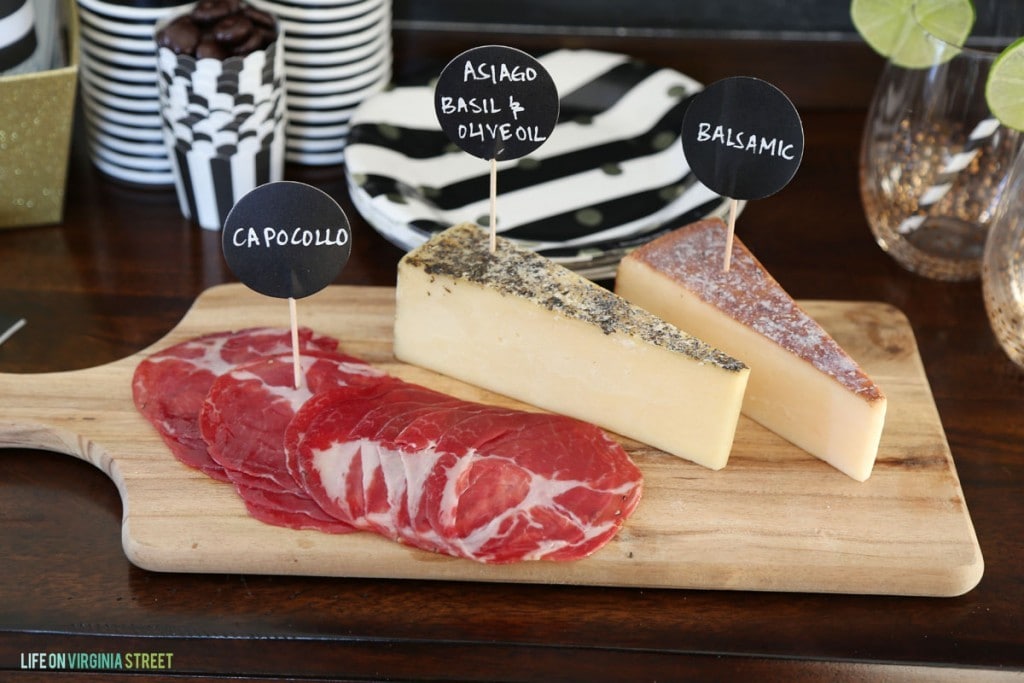 Meet and Cheese Tray on the table beside paper plates.