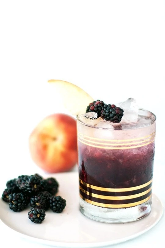 Peach and Blackberry Bramble with blackberries beside it and a peach behind it.