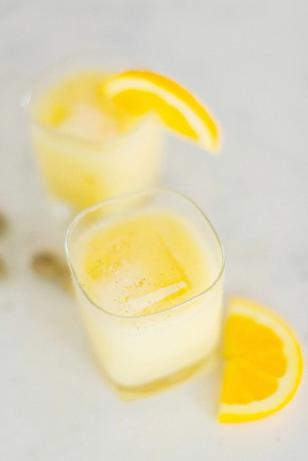 The Painkiller with orange slices on the glass and on the table.