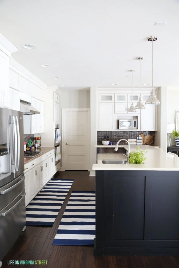 White Kitchen with Black Island and Navy striped runner rugs - Life On Virginia Street