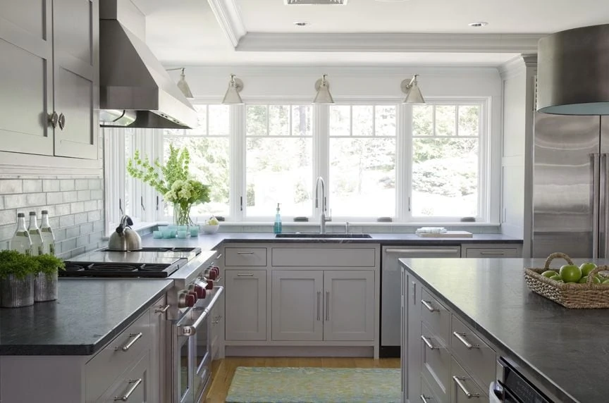 Gray Kitchen with swing arm lights and fruit in a basket on the kitchen island.