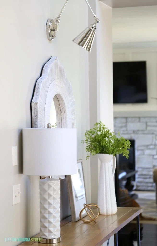 Silver sconce above the mirror in hallway.