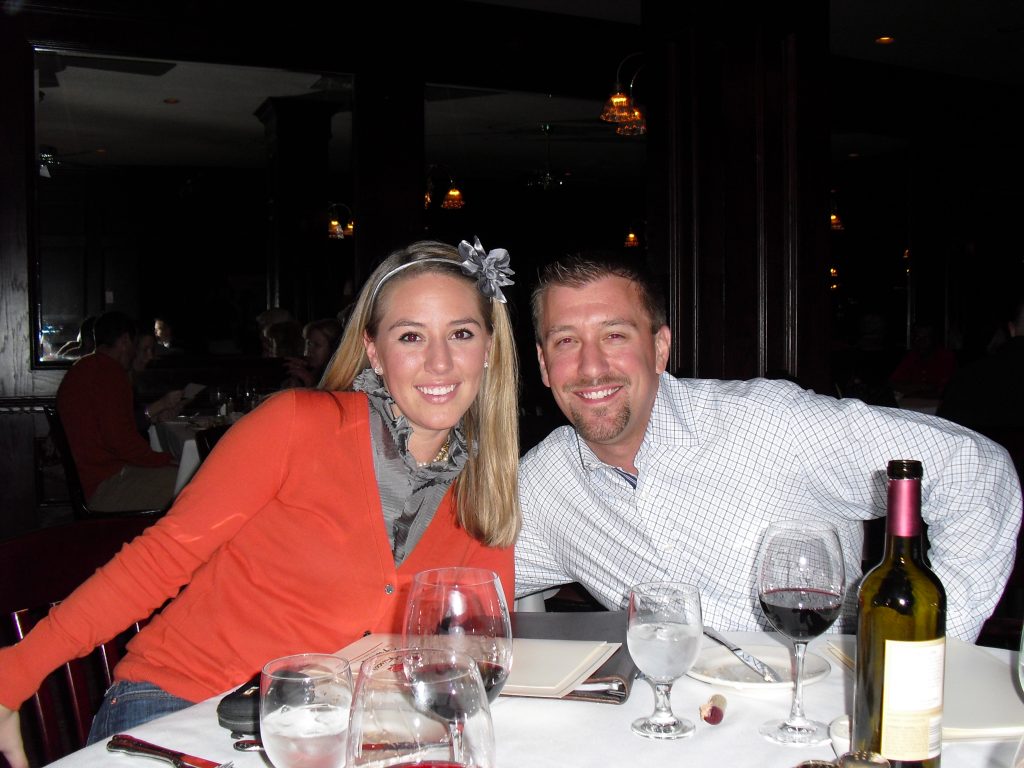 Sarah and Kurtis posing at the table with Sarah wearing a floral headband.