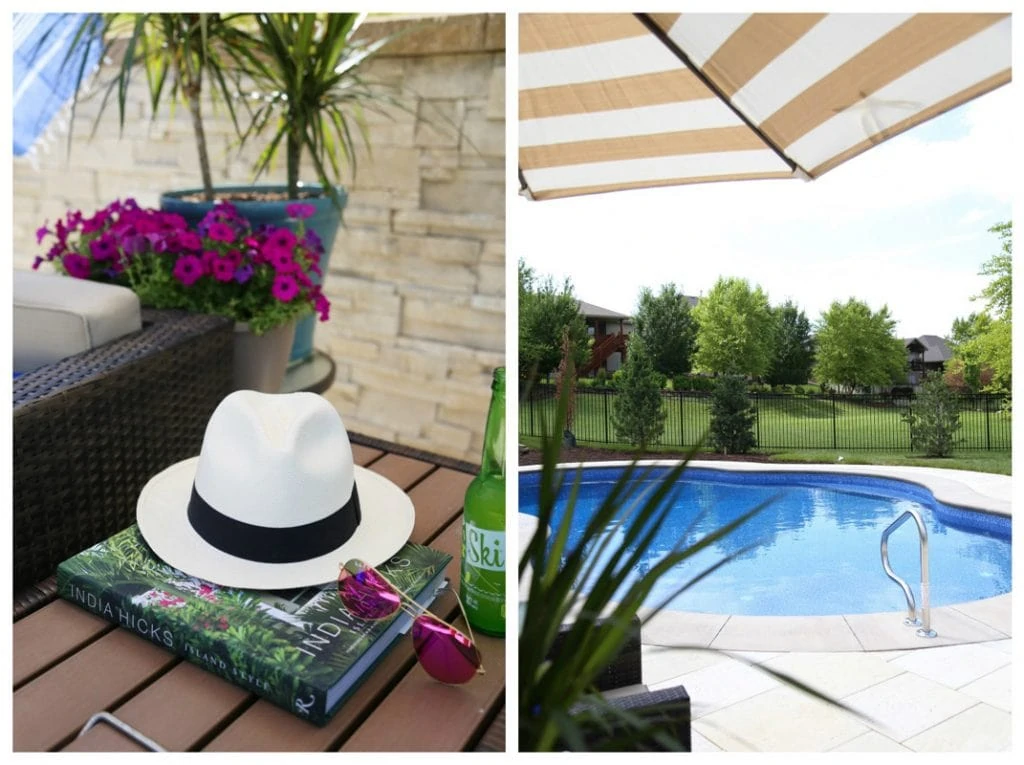 A white and black hat, a book and sunglasses on the small table beside the pool.
