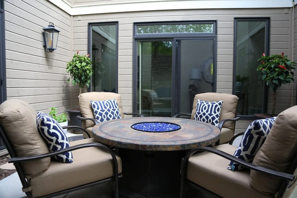 Courtyard with four chairs and a round table.