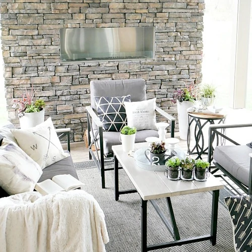 Stone wall with outdoor table and chairs.