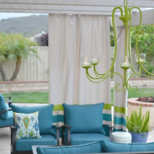 Outdoor chandelier with a blue couch.