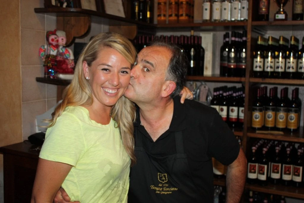 An Italian wine maker kissing Sarah on the cheek.