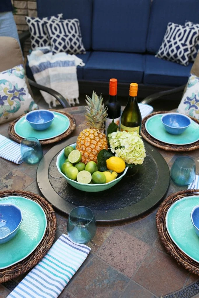 Summer Patio with wine, fruit and the table set on the patio.