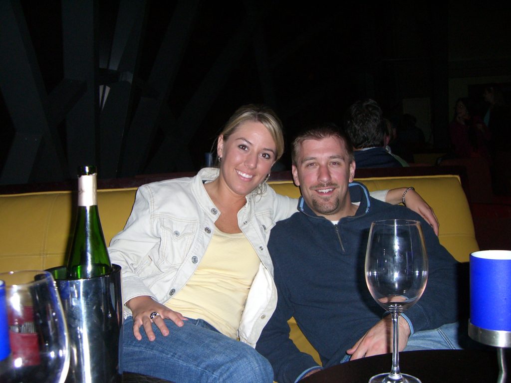 A bottle of wine chilling with Sarah and Kurtis in the background.