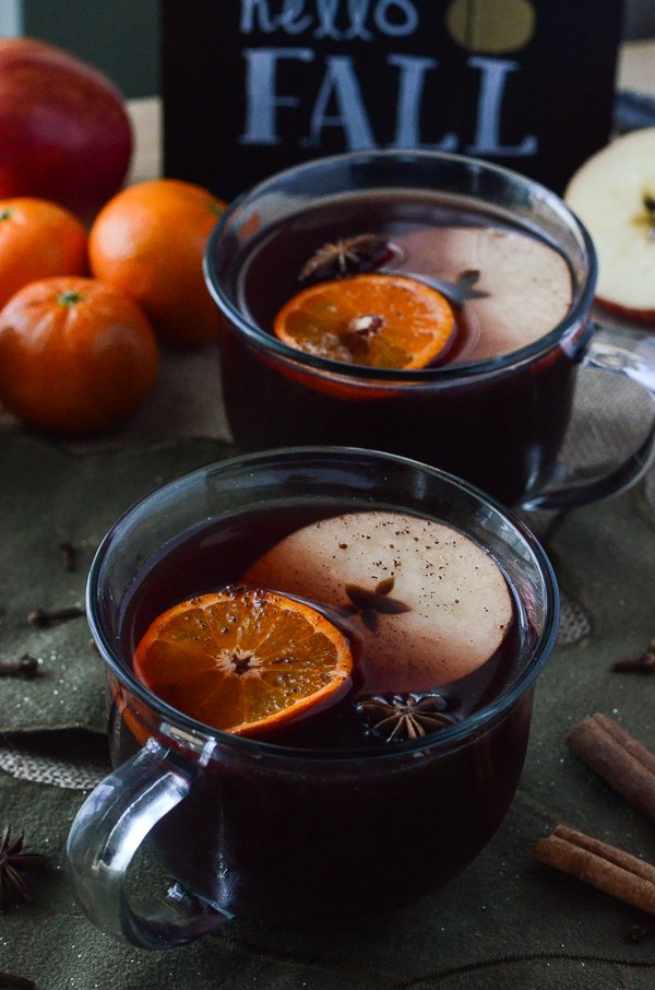Hot mulled wine in a mug with orange slices and star anise.