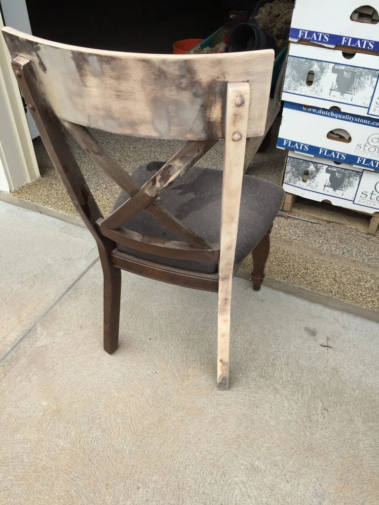 Sanding dark stain off of a dining room chair.