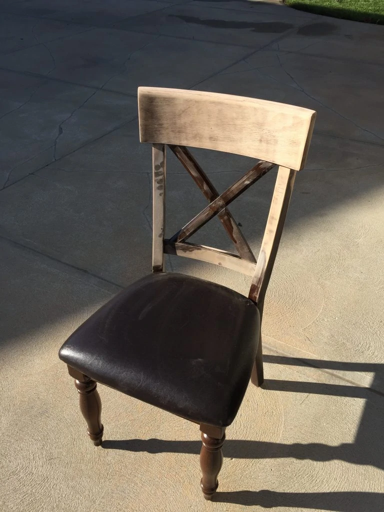 The chair being sanded with a dark leather cushion.