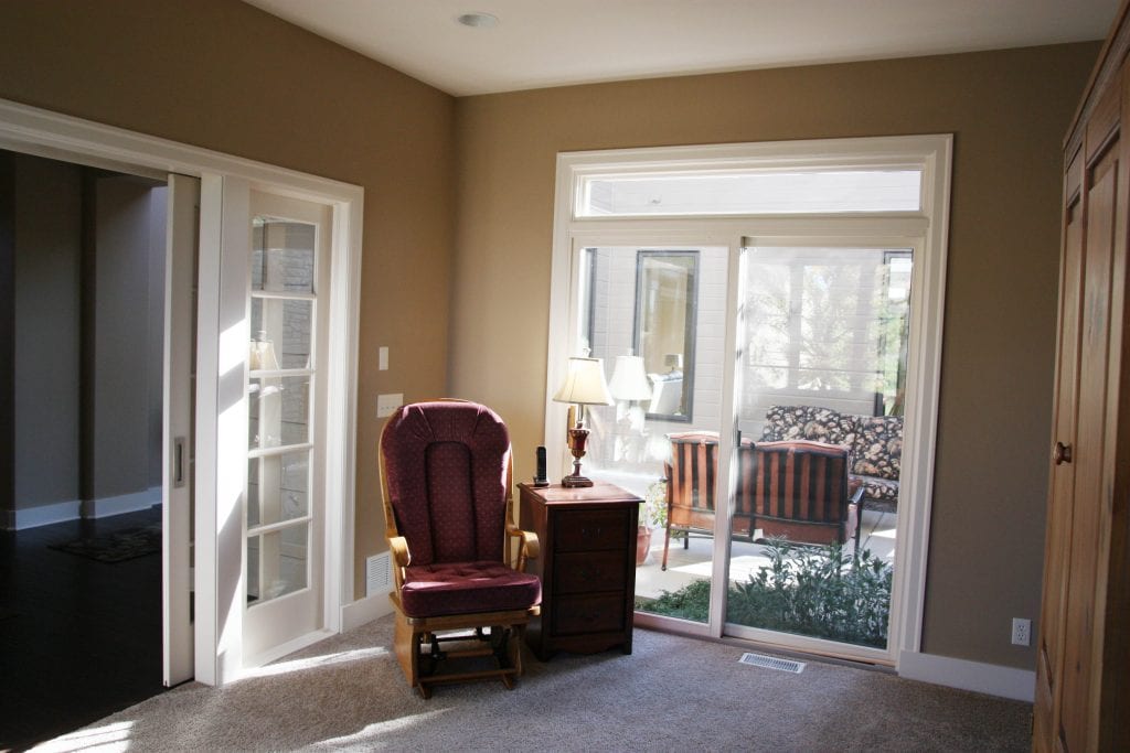 A rocking chair is in front of the sliding door leading to the courtyard.
