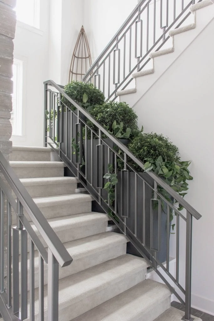 Neutral staircase with gray metal railings via Omaha Street of Dreams. Image via Mandy McGregor Photography.