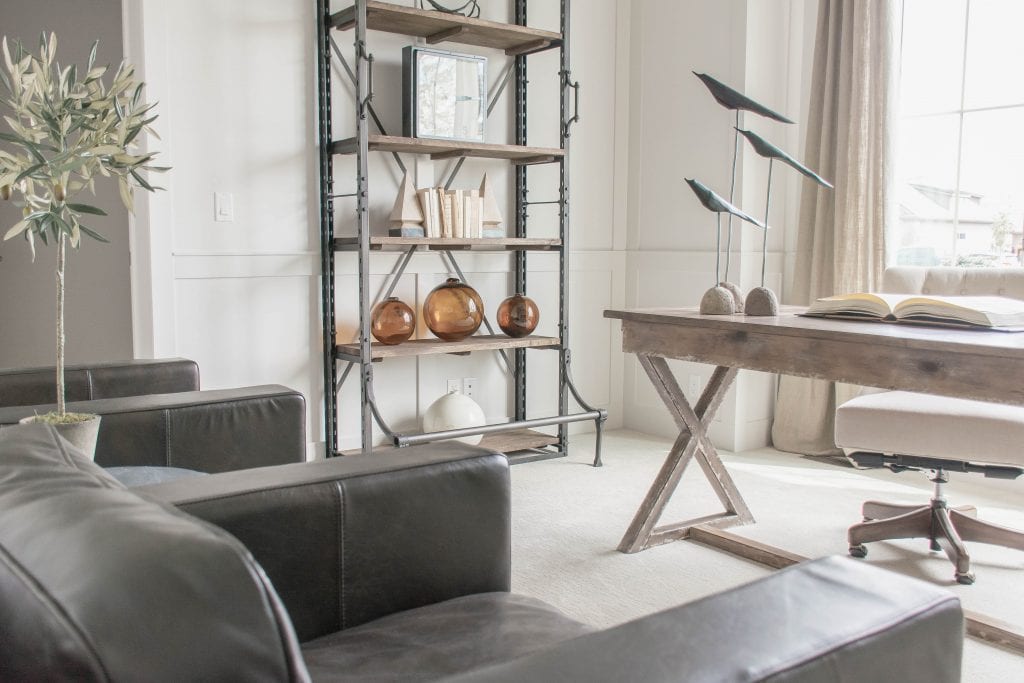 Neutral office with wood beams, white walls, olive tree and wood and leather accents via Omaha Street of Dreams. Image via Mandy McGregor Photography.