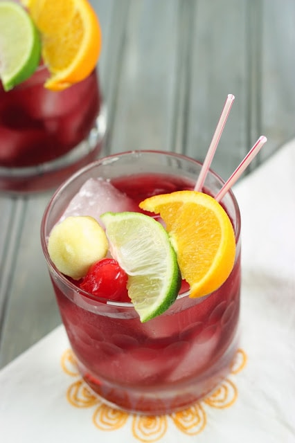 Red sangria with slices of lemon and lime on top.