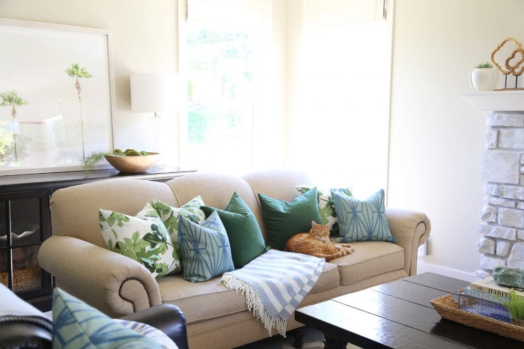 Neutral fabric couch with pillows on it.