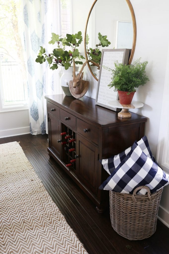 Dark wooden hutch in living room with wine bottles in it.