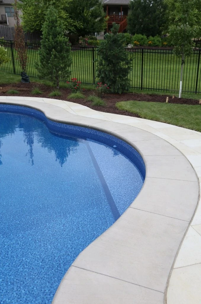 A pool with coping and pavers. 