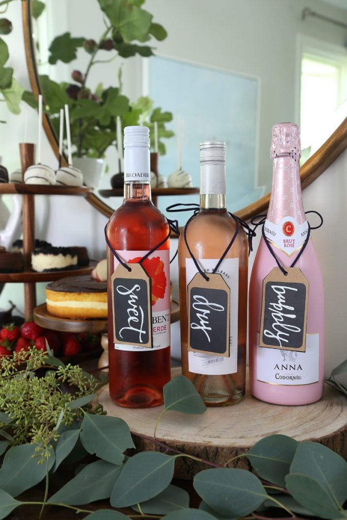 Three bottles of wine on a wooden serving tray.