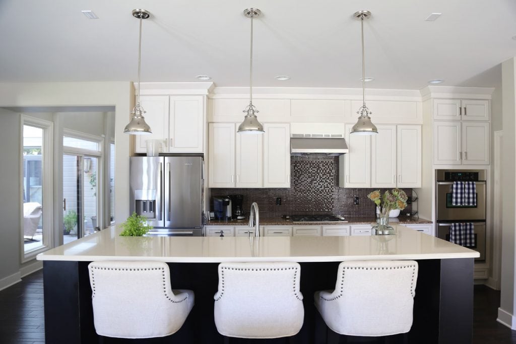 white-kitchen-cabinets-with-black-island-and-linen-barstools-via-life-on-virginia-street