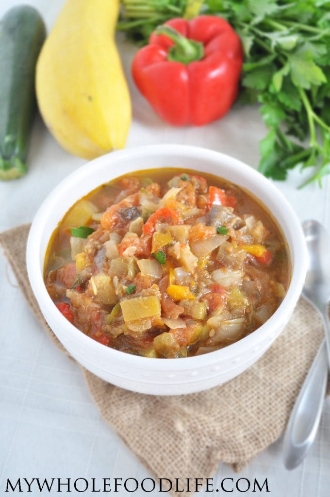 Ratatouille soup on a white counter surrounded with vegetables.