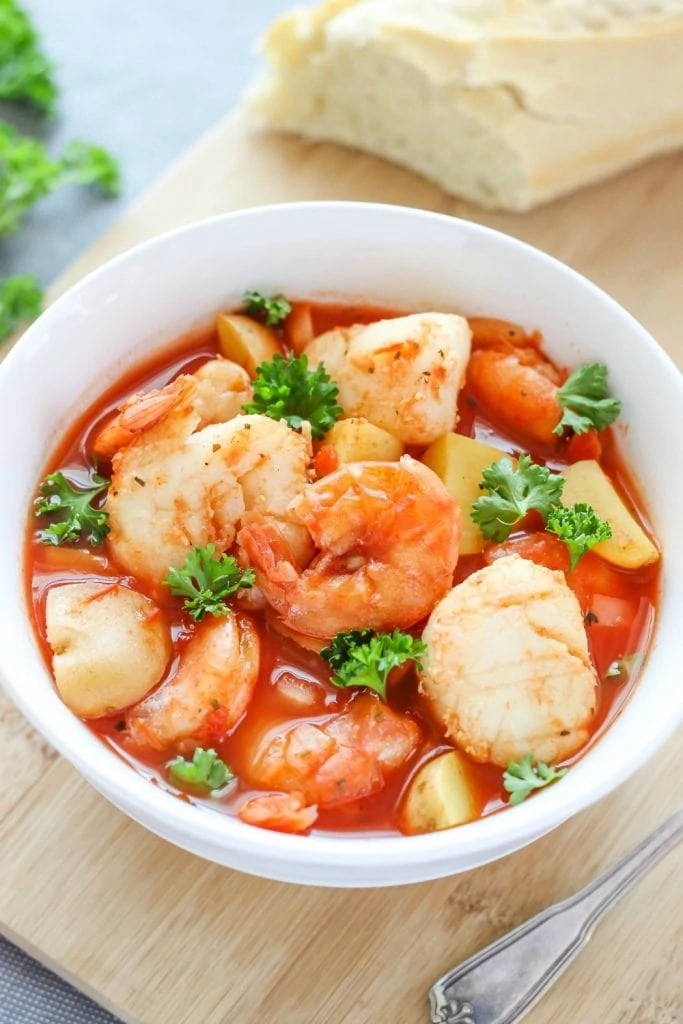 Seafood stew with shrimp on top.
