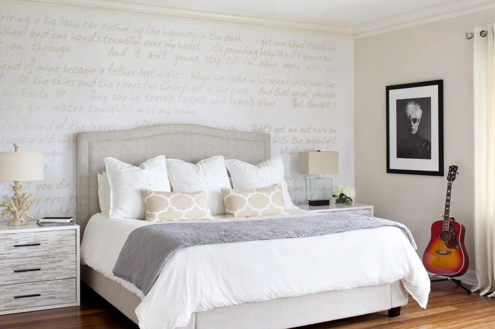Neutral bedroom with song lyrics on wall