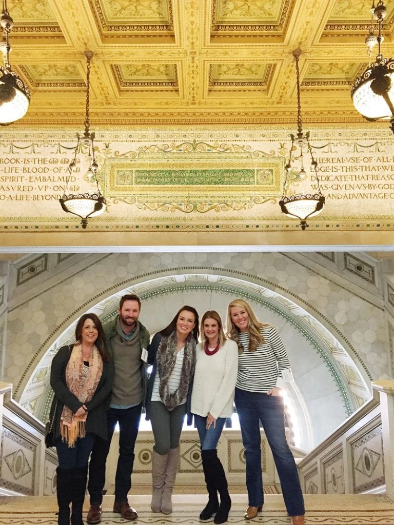 The blogger influencers taking a picture in front of the ornate ceiling, tile and chandeliers.