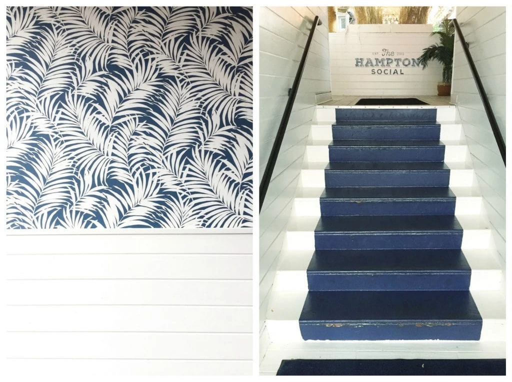 Navy and white wallpaper, and a navy blue painted runner on the stairs.