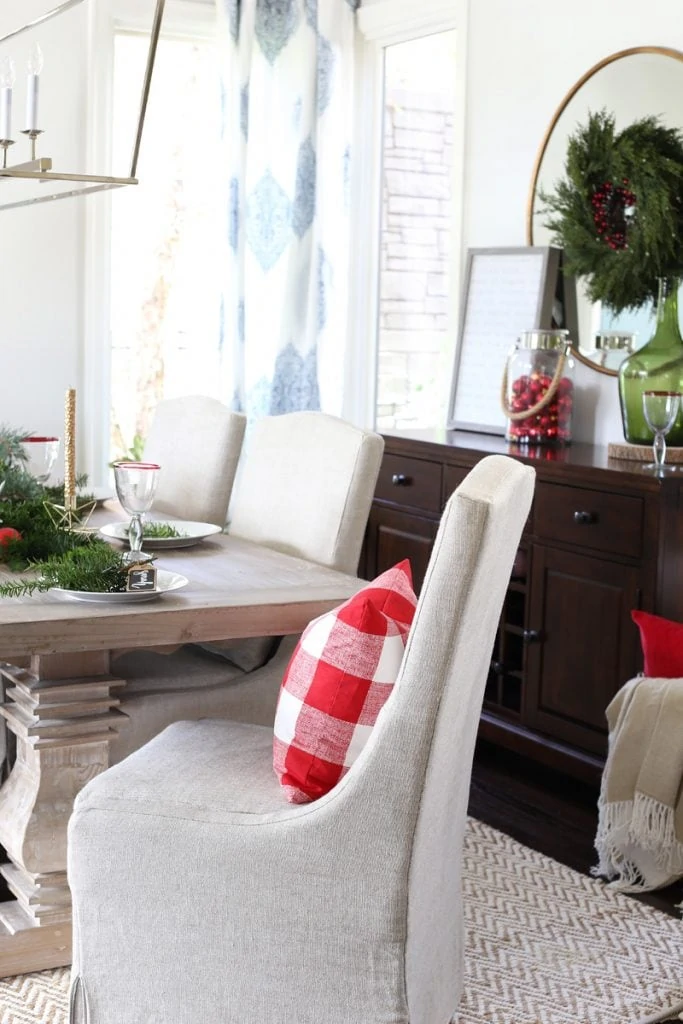 Christmas dining room with Orient Express Collette Dining Chair and a checkered red and white pillow on it.