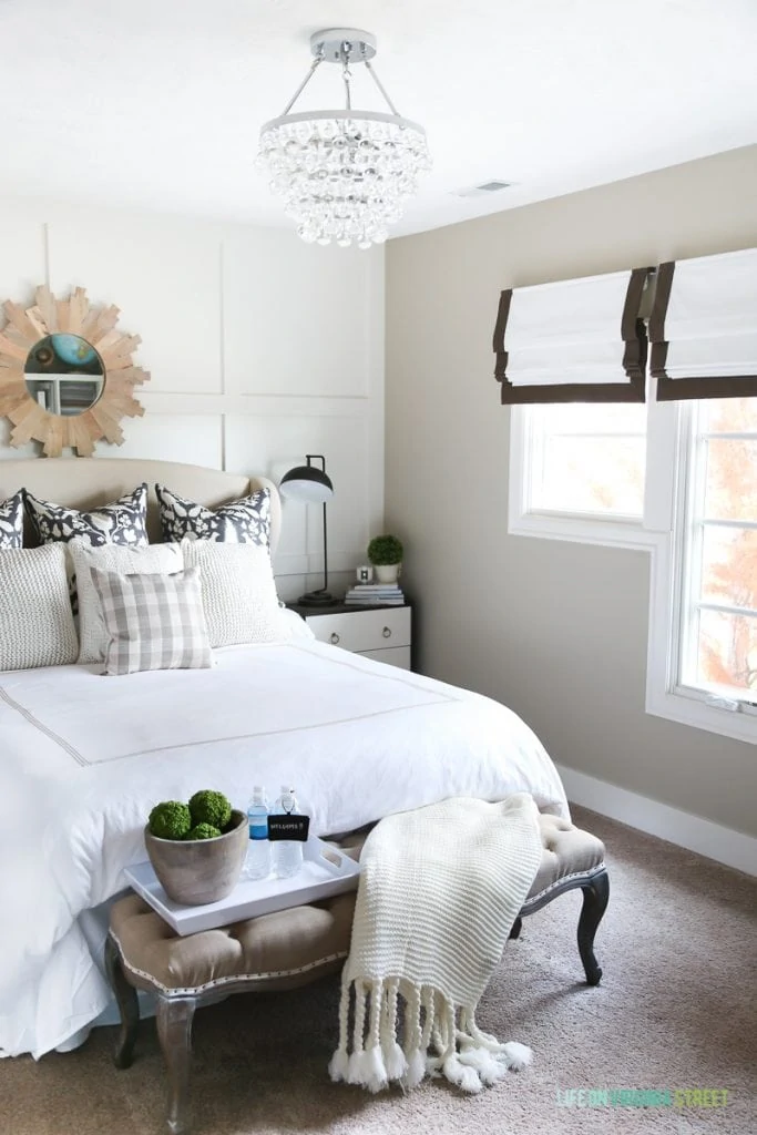 Guest bedroom with neutral bedding and green accents. Great tips on how to prepare your guest bedroom for the holidays!