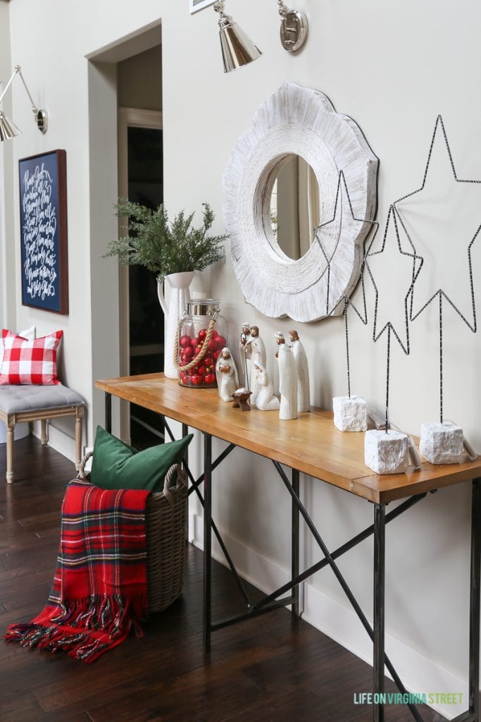 Hallway Christmas decor with red plaid, metal stars and nativity scene.