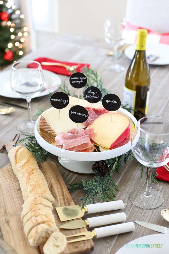 Cheese platter with a sliced loaf of bread beside it.