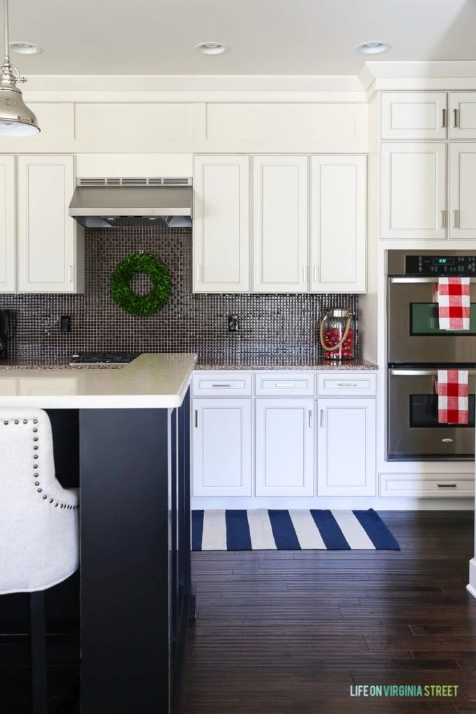 White kitchen cabinets with wreath hanging above sink in the kitchen.