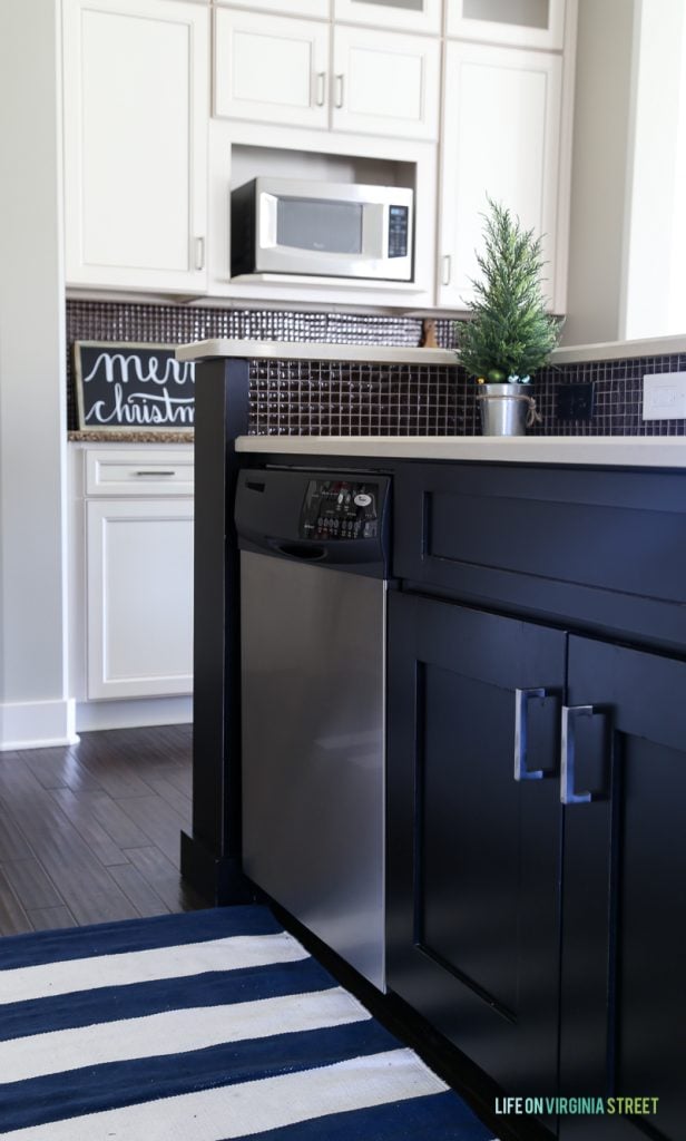 A dark blue kitchen island with a built in dishwasher.