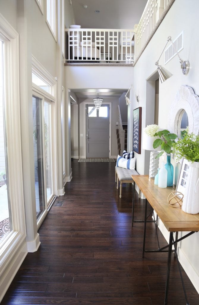 Light and bright hallway with dark hand-scraped oak floors and chrome swing-arm sconces.