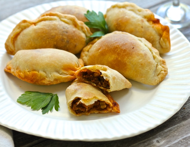 Beef empanadas on a white plate.